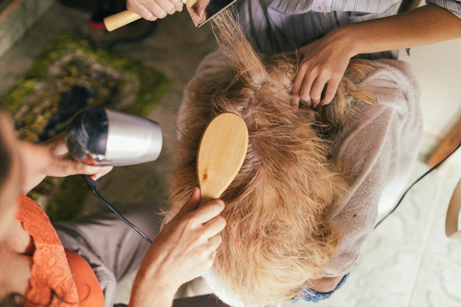 person pouring water on womans hair